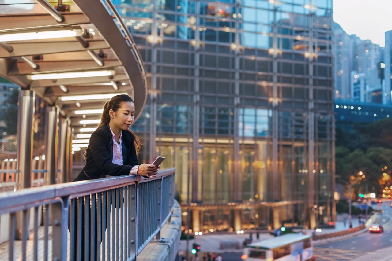 woman-with-smartphone-on-pedestrian-bridge-getty-993924942.jpg