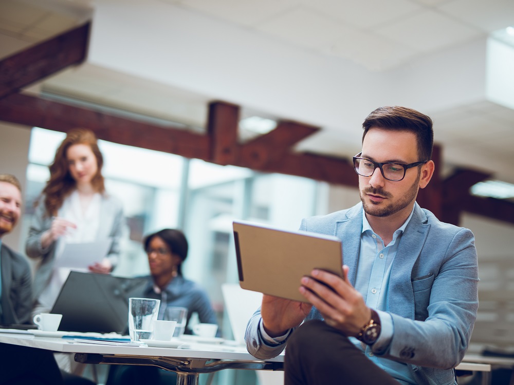 man-in-suit-looking-at-ipad.jpg