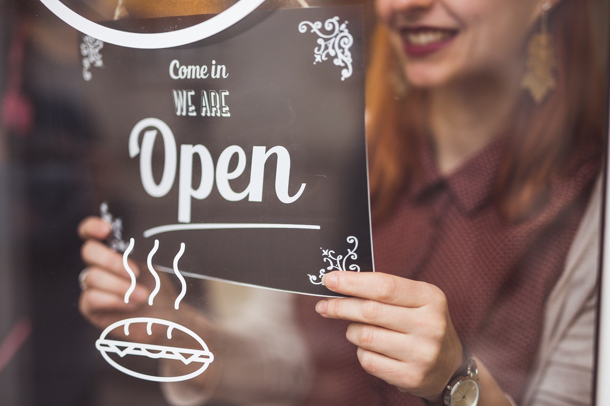 woman setting open sign small business owner getty 908054780